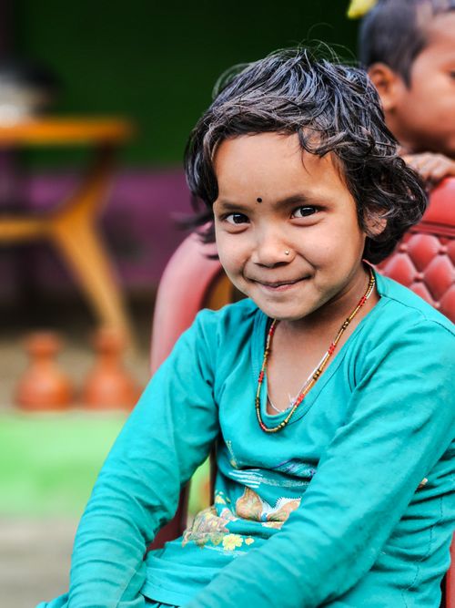 Free Charming young girl smiling in traditional attire, bright colors, candid outdoor portrait. Stock Photo