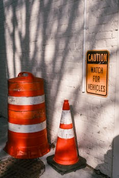 Traffic cones and caution sign create a safety warning at a construction site.