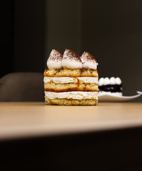 Free Close-up of a tiramisu slice on a table, perfect for dessert and food-related visuals. Stock Photo
