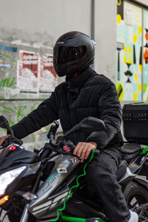 Free Motorcyclist wearing black gear riding through Ankara streets, showcasing urban biker lifestyle. Stock Photo