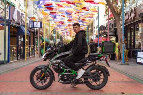Free A young man on a motorbike in a colorful street in Ankara, Türkiye. Stock Photo