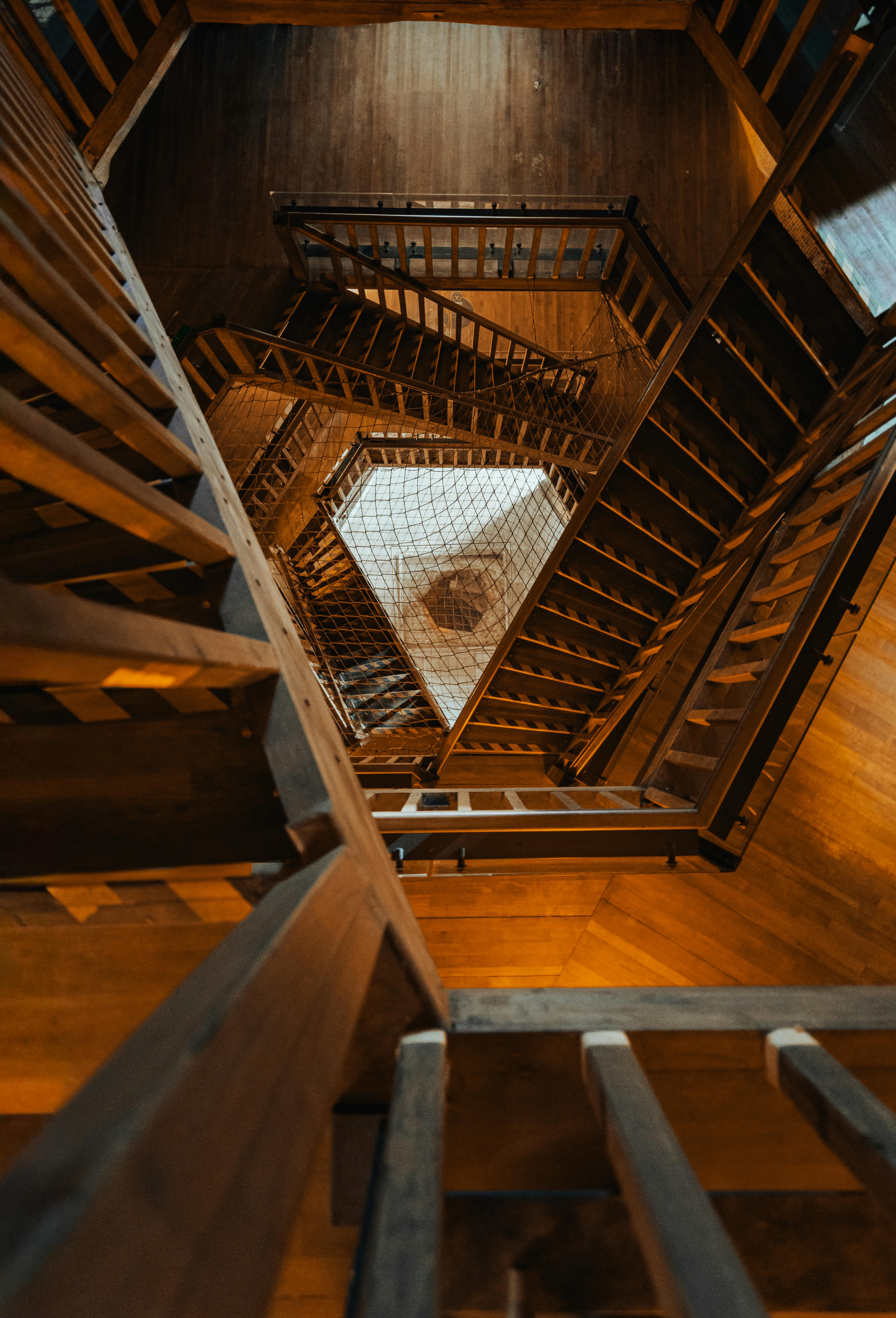 Dramatic view of a multi-level wooden staircase showcasing geometric artistry from above.