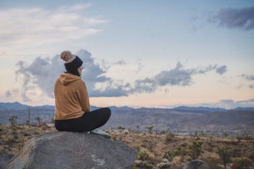 бесплатная Женщина, сидящая на скале Стоковое фото