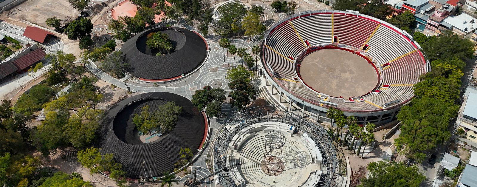 Aerial shot of sports complex in Chilpancingo showing large circular arenas surrounded by trees.