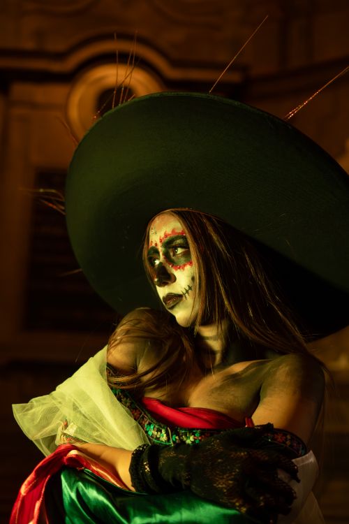 Free Woman in Day of the Dead makeup and costume, wearing a large black hat, embracing cultural heritage. Stock Photo