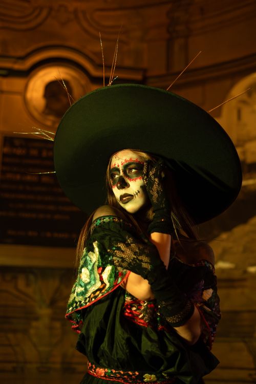 Free Woman in Dia de los Muertos costume with face paint, striking a dramatic pose. Stock Photo
