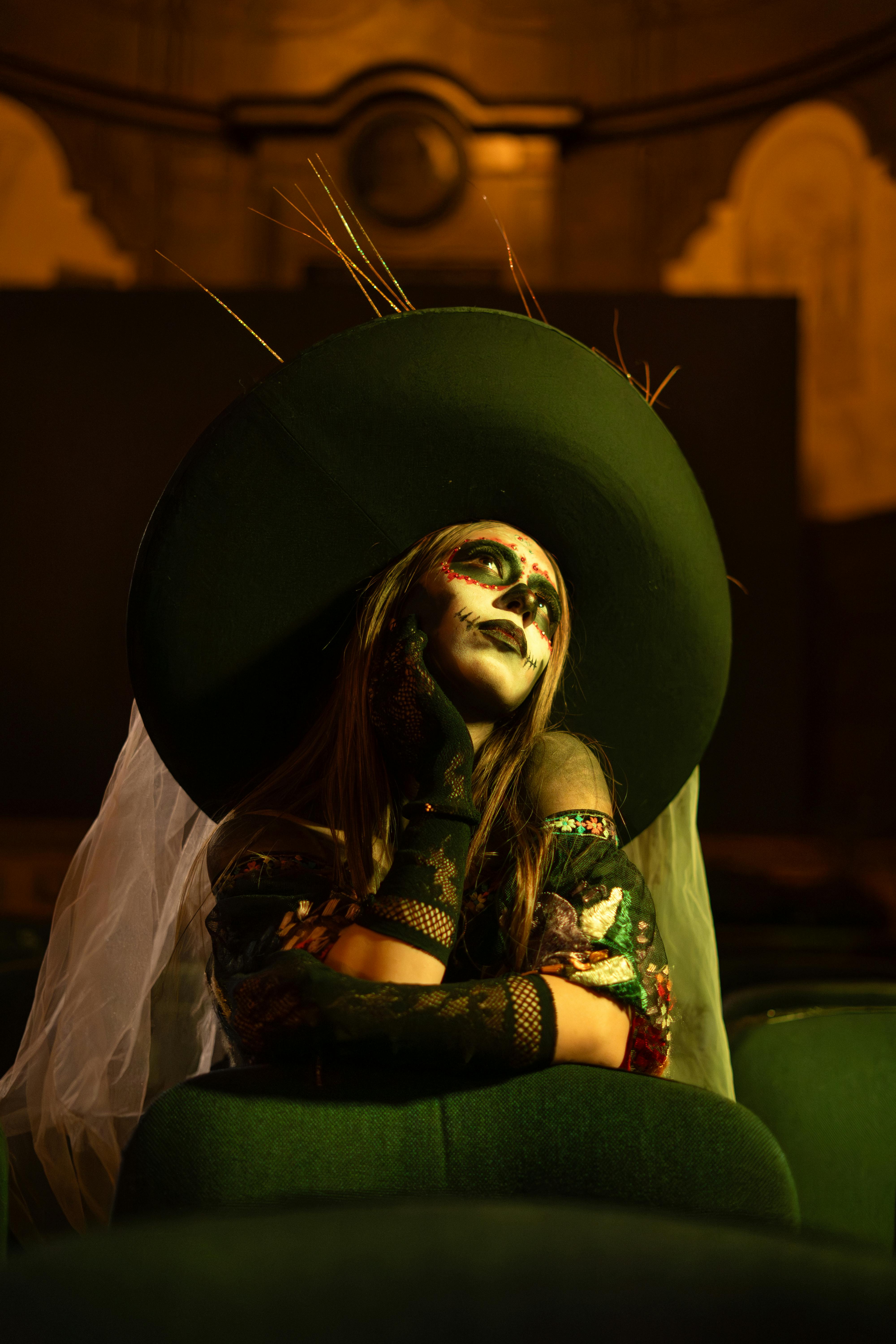 Gratis Kvinde med kunstnerisk makeup i vintage teatermiljø, der udstråler mystik og drama. Lagerfoto