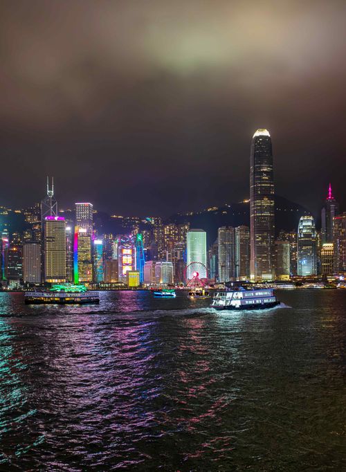Free A stunning view of the illuminated Hong Kong skyline reflecting in the harbor waters during nighttime. Stock Photo