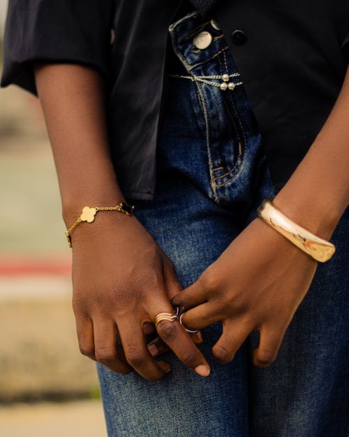 Free Close-up of hands with elegant bracelets and rings, denim jeans in background. Stock Photo