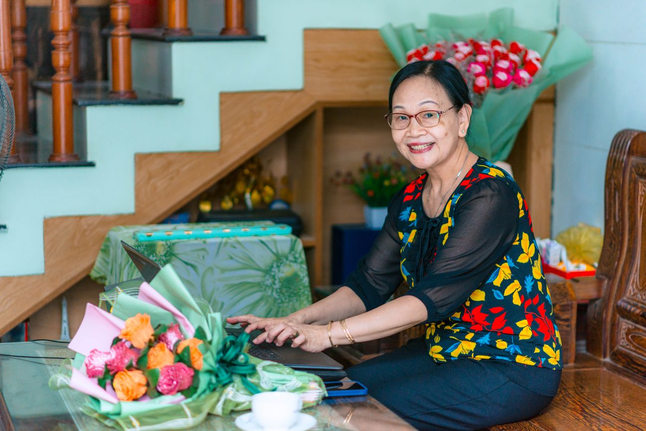 A smiling woman browsing options on a laptop at home
