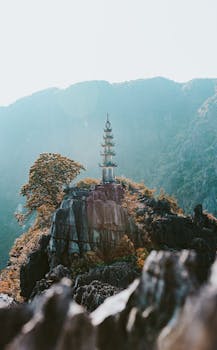 越南宁邦岩石悬崖上的一座塔，周围环绕着郁郁葱葱的绿色植物，景色令人惊叹