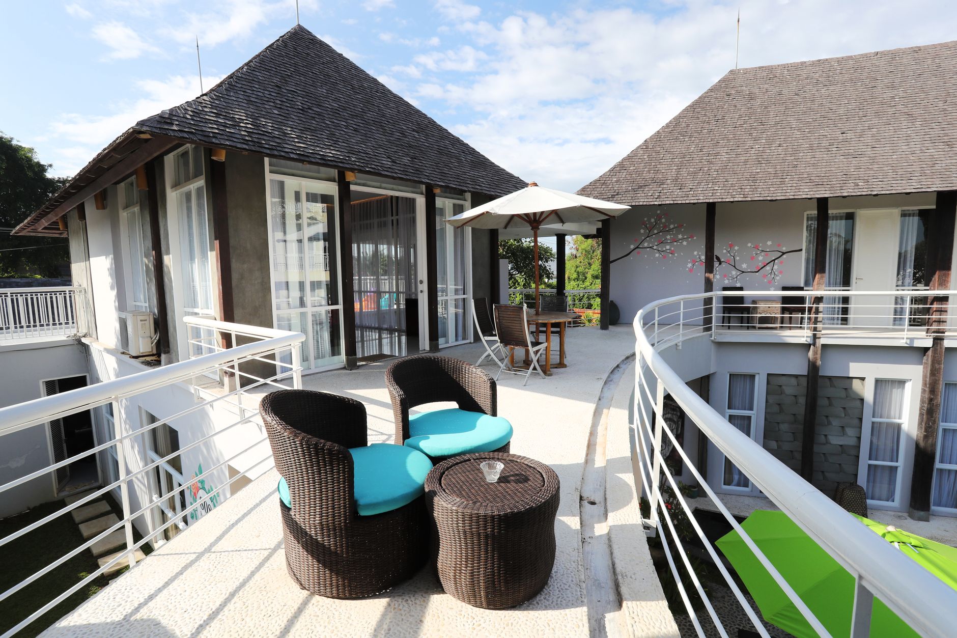 Stylish resort terrace in Bali featuring modern furniture and scenic outdoor view.