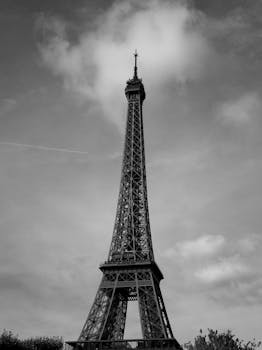 Black and white photo of the Eiffel Tower, showcasing Paris's iconic architecture.