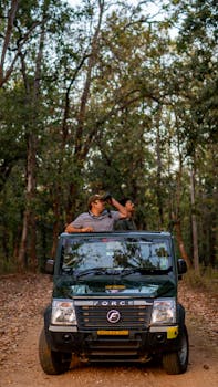 Two men enjoying a safari adventure in an Indian forest, exploring nature and wildlife.