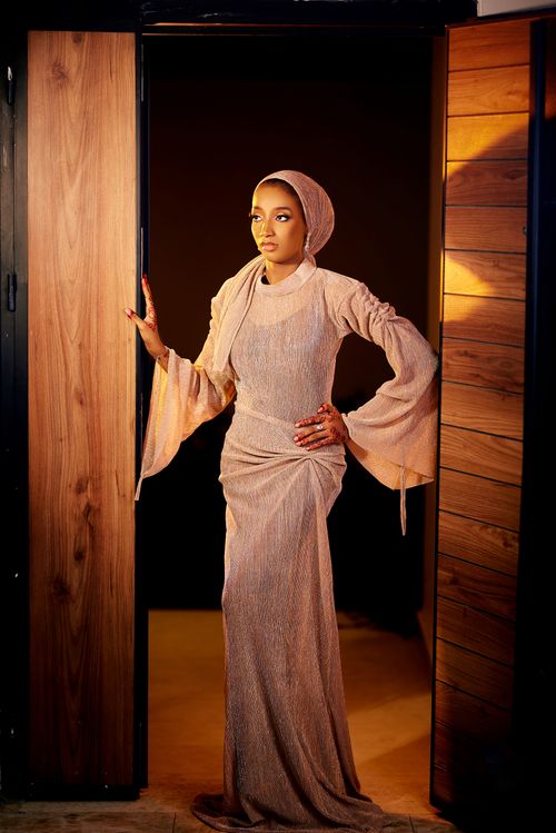 Free A stylishly dressed woman poses confidently in a doorway with a warm, elegant atmosphere. Stock Photo