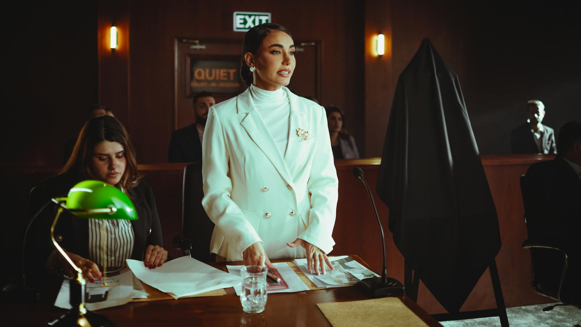 Female lawyer in white suit presenting a case confidently in a courtroom setting in Baghdad, Iraq.