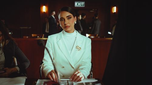 Free Elegant woman in a white suit attending a formal meeting in a conference room. Stock Photo