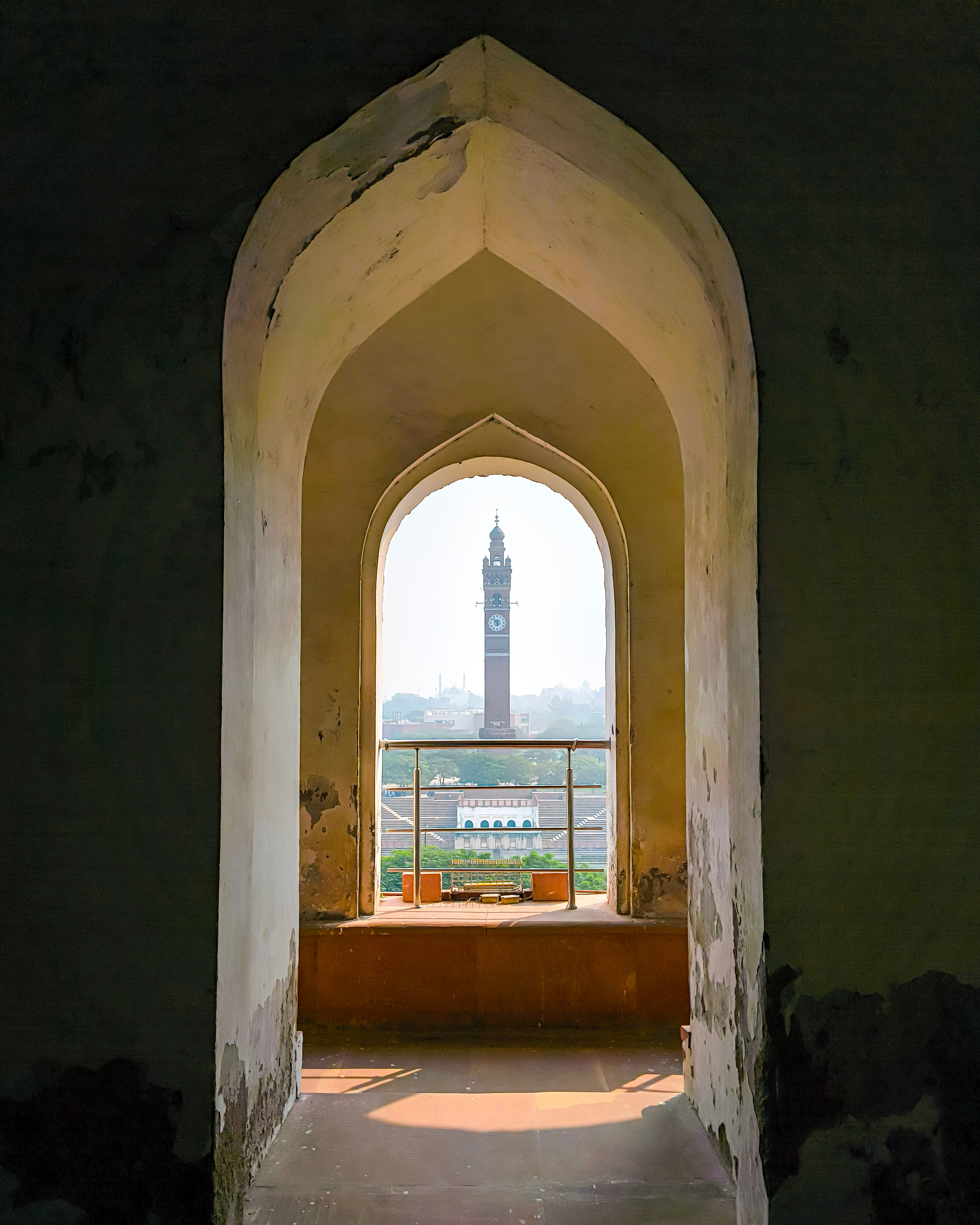 View of Lucknow's clock tower framed through a historic architectural archway.