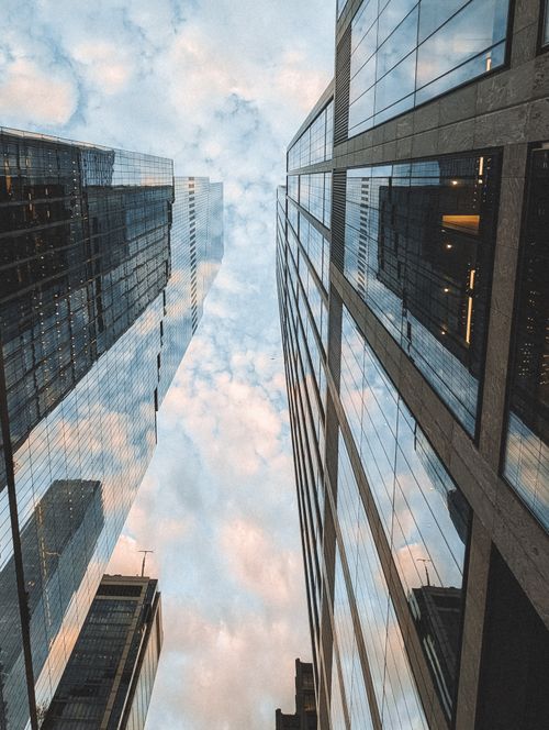 Free Dramatic skyscraper reflections in New York City with cloudy sky above. Stock Photo