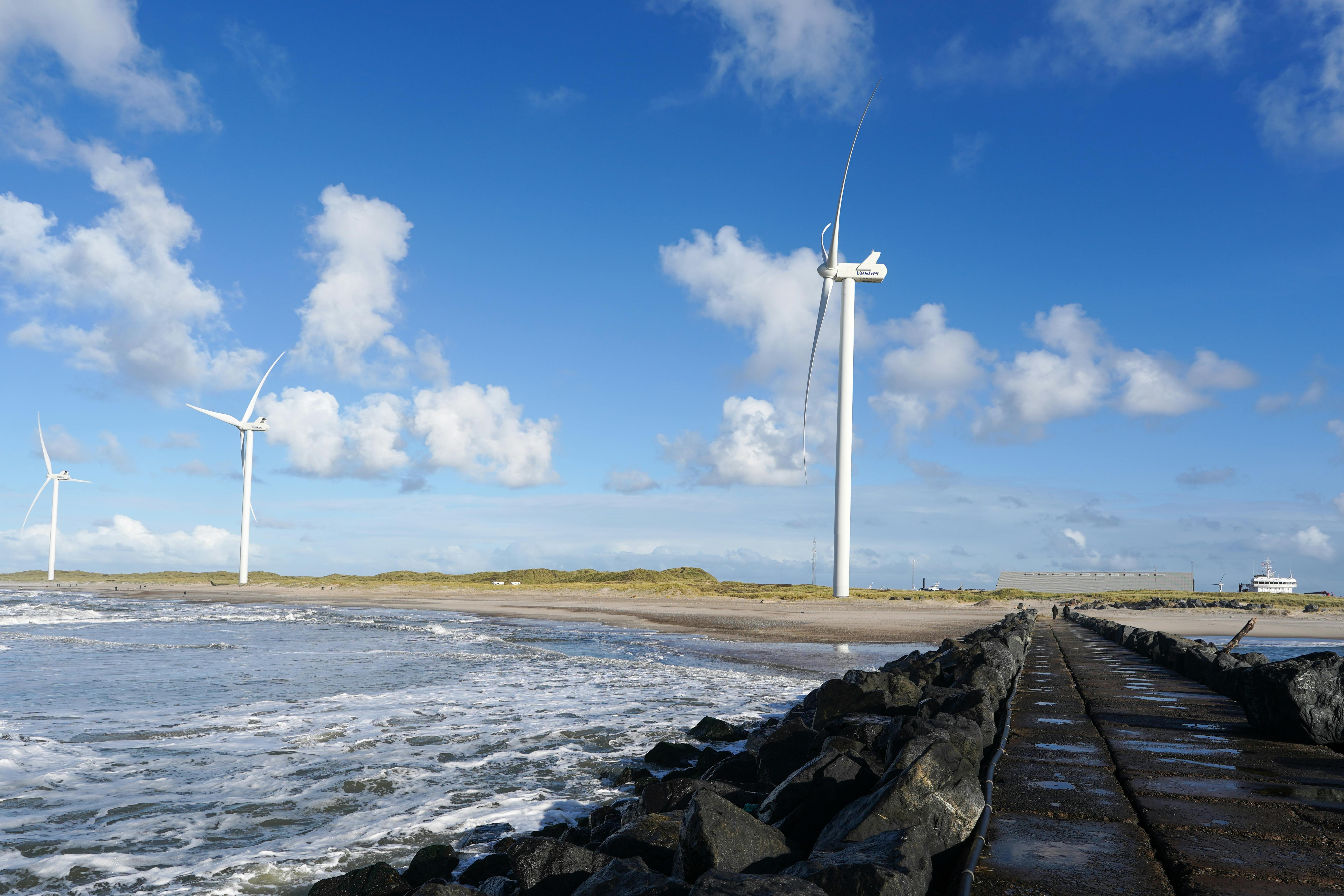 Tranquil coastal scene with wind turbines at Hvide Sande, Denmark, showcasing sustainable energy.