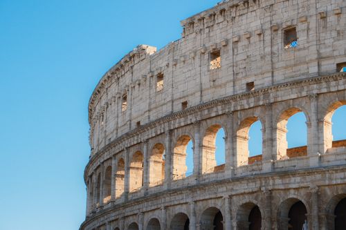 Free Capture of the iconic Colosseum in Rome, Italy, against a clear blue sky. Stock Photo