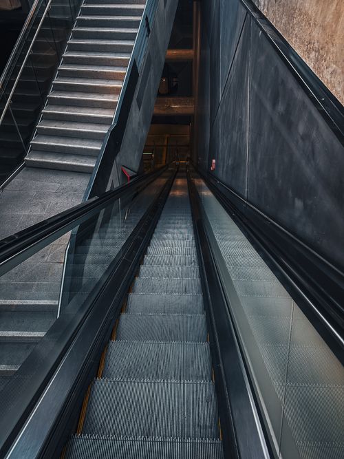 Free Perspective view of a modern escalator and staircase indoors, showcasing an urban design. Stock Photo