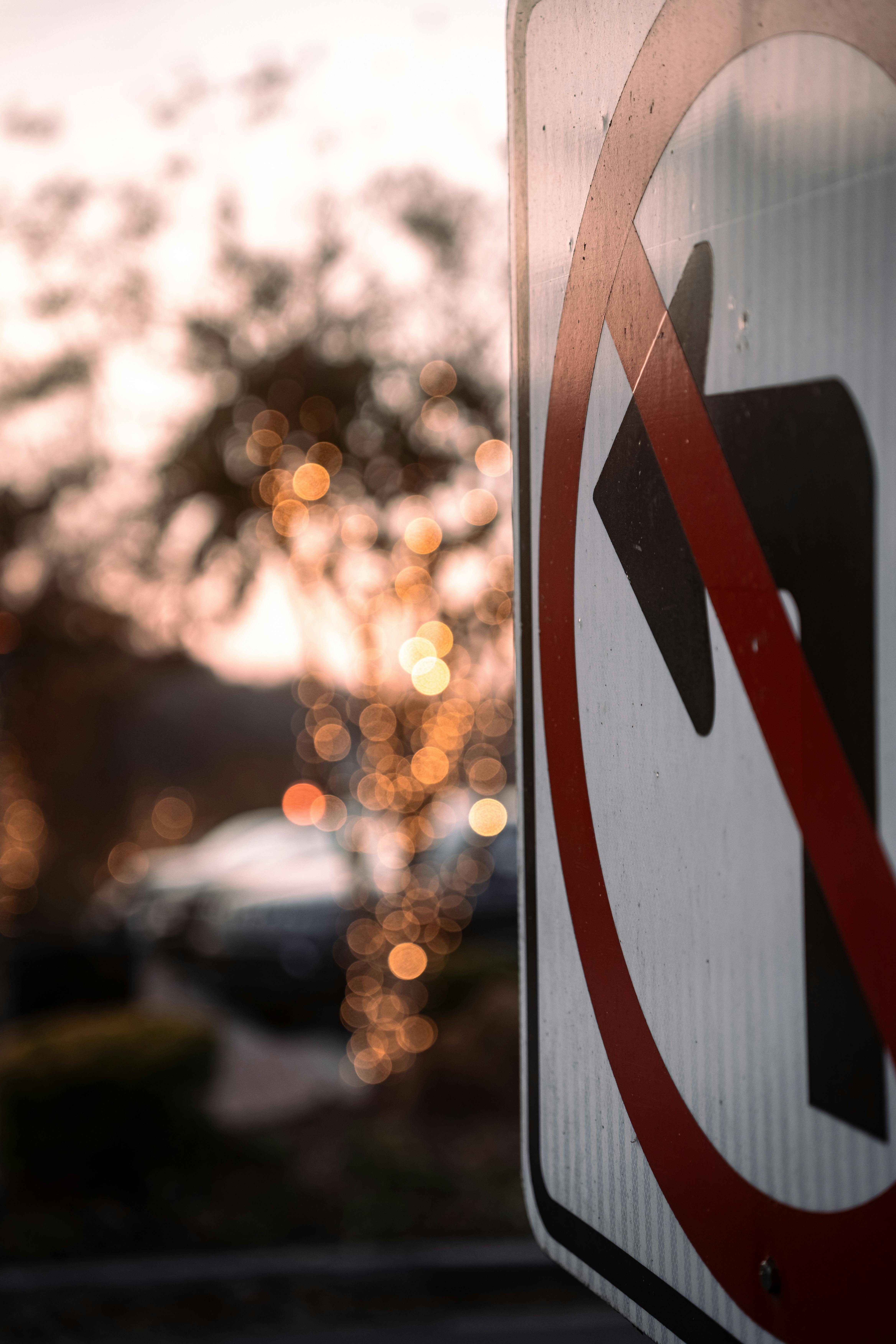 Close-up of a 'No Left Turn' sign against a blurred, bokeh-lit background, evoking a moody, urban feel.