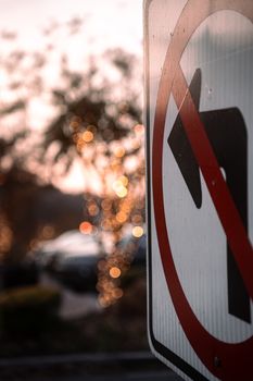 Close-up of a 'No Left Turn' sign against a blurred, bokeh-lit background, evoking a moody, urban feel.
