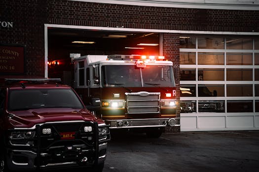 A fire truck exits the station, lights flashing, ready for emergency response.