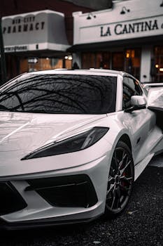 A sleek white sports car in front of urban buildings, highlighting modern design and style.