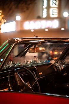 Classic car interior decorated festively, captured at night with blurred city lights in background.