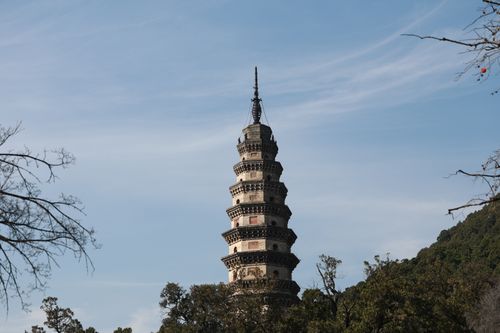 Free A stunning ancient pagoda tower amidst nature with a clear blue sky backdrop. Stock Photo