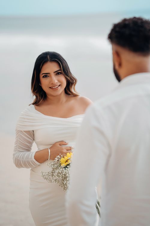 Free Couple enjoying a romantic engagement photo shoot on a serene beach. Stock Photo