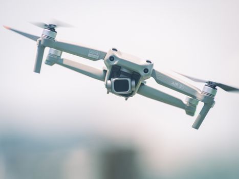 Close-up of a drone in flight, showcasing modern technology and design against a bright sky.
