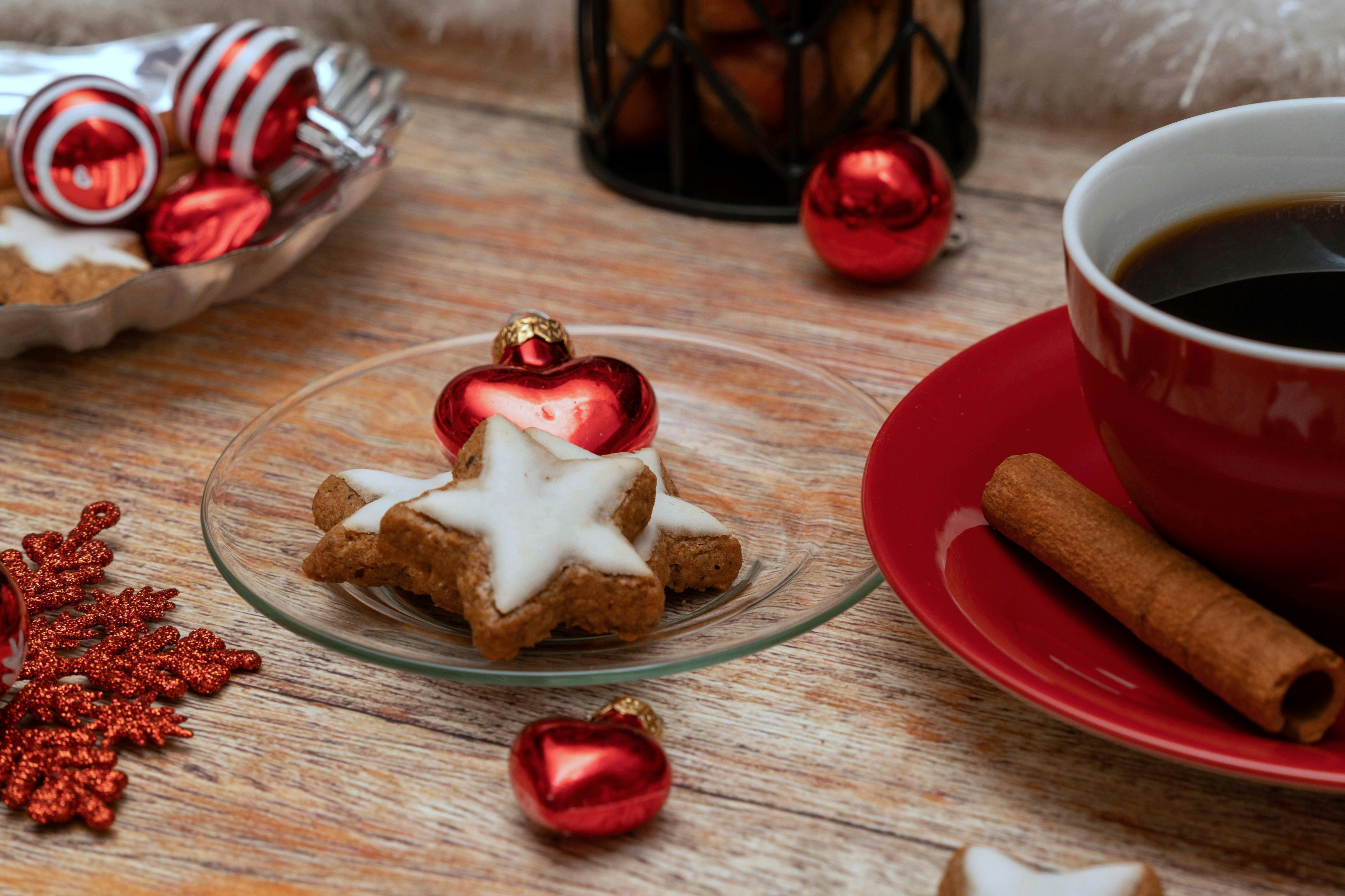 Festive holiday scene with star cookies, cinnamon, coffee, and decorations for a warm winter mood.