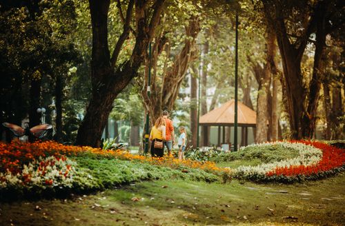 Free A family enjoys a peaceful walk in a vibrant park in Ho Chi Minh City, Vietnam. Stock Photo