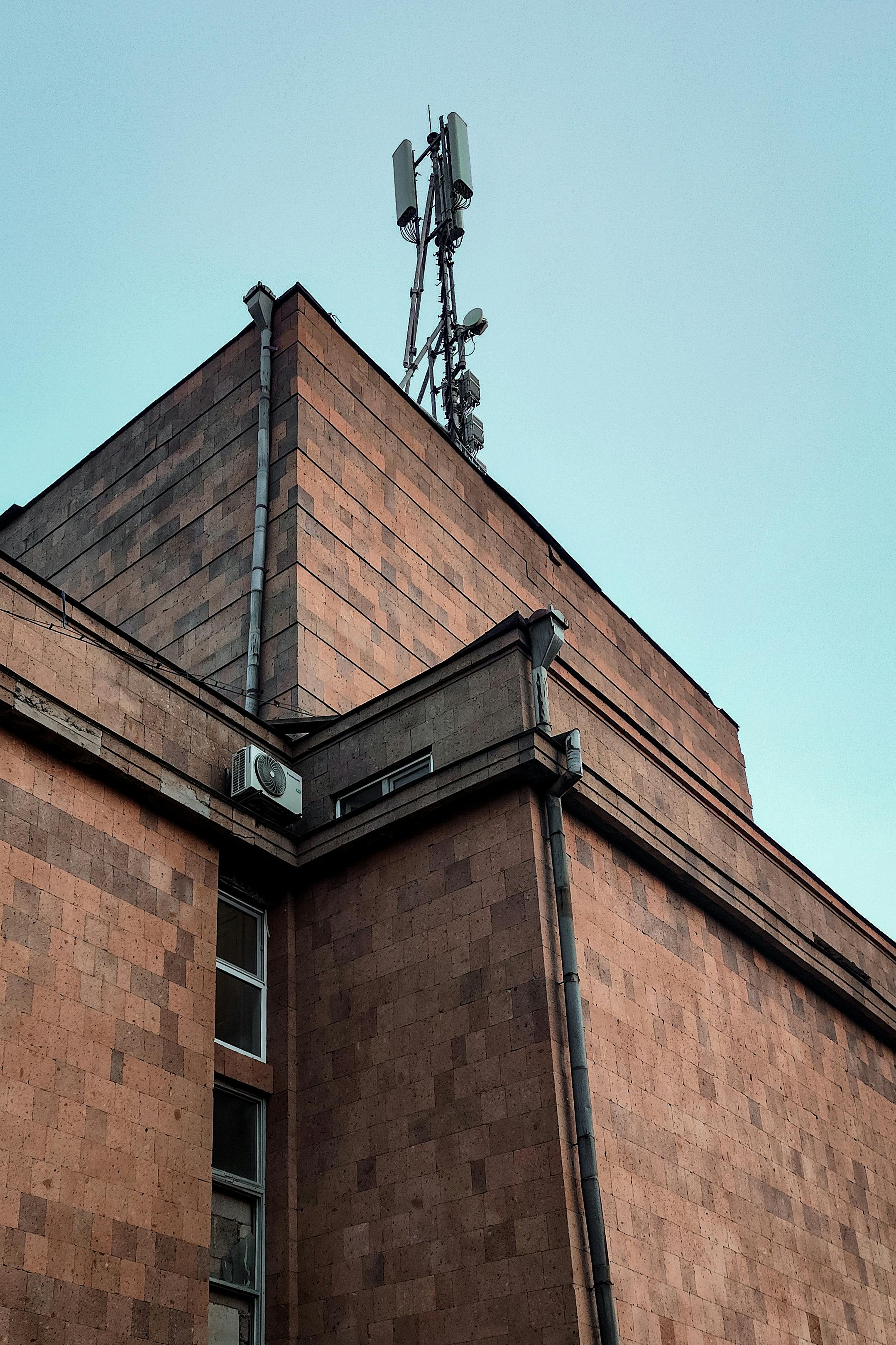 бесплатная Вид на архитектурное сооружение с антенной в Ереване, Армения, иллюстрирующий городскую инфраструктуру. Стоковое фото