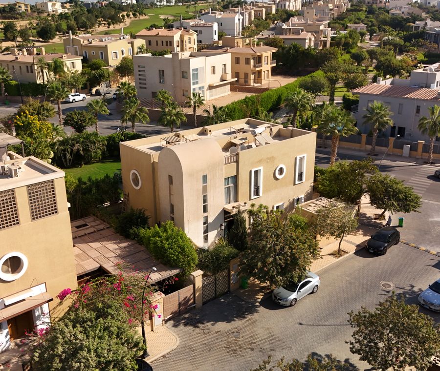 Aerial image showcasing modern villas and greenery in a luxury community in West Cairo, Egypt, perfect for real estate i