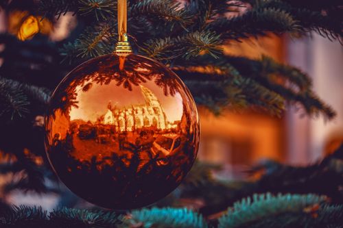 Free A reflective Christmas ornament on an evergreen tree captures a festive scene. Stock Photo