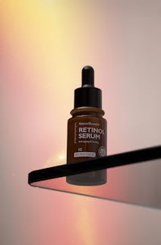 A retinol serum bottle on a glass shelf with a warm gradient backdrop.