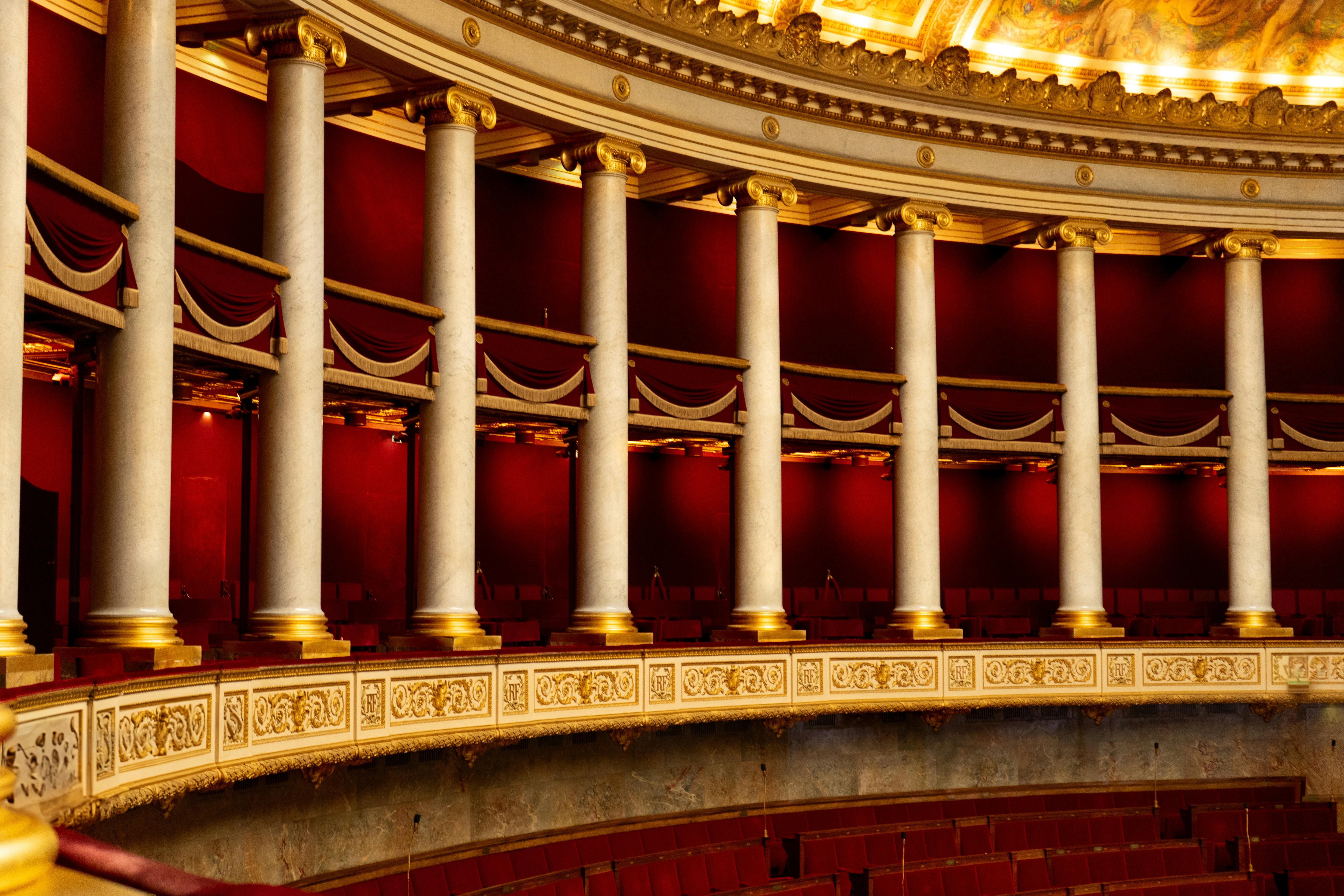 Free Beautiful ornate interior of an opera house balcony showcasing rich red and gold decor. Stock Photo