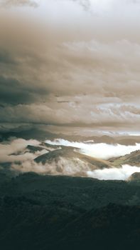 A captivating view of misty mountains under dramatic clouds in France, showcasing nature's beauty.