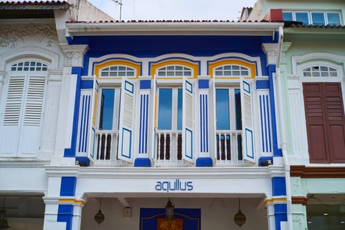 Free Vibrant colonial-style building facade with blue, white, and yellow design on a sunny day. Stock Photo