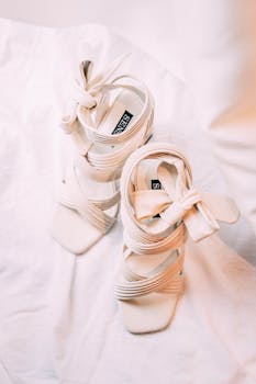 白色高跟鞋时尚优雅，搭配柔软的面料背景，尽显女性气质