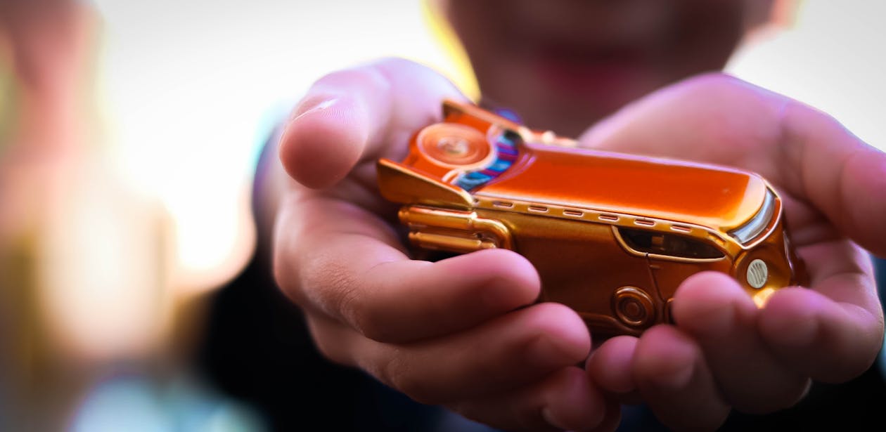 Person Holding Gold Car Toy