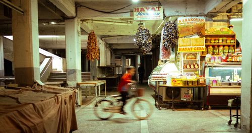 Free A child cycles through a vibrant indoor market, with spices and goods on display. Stock Photo
