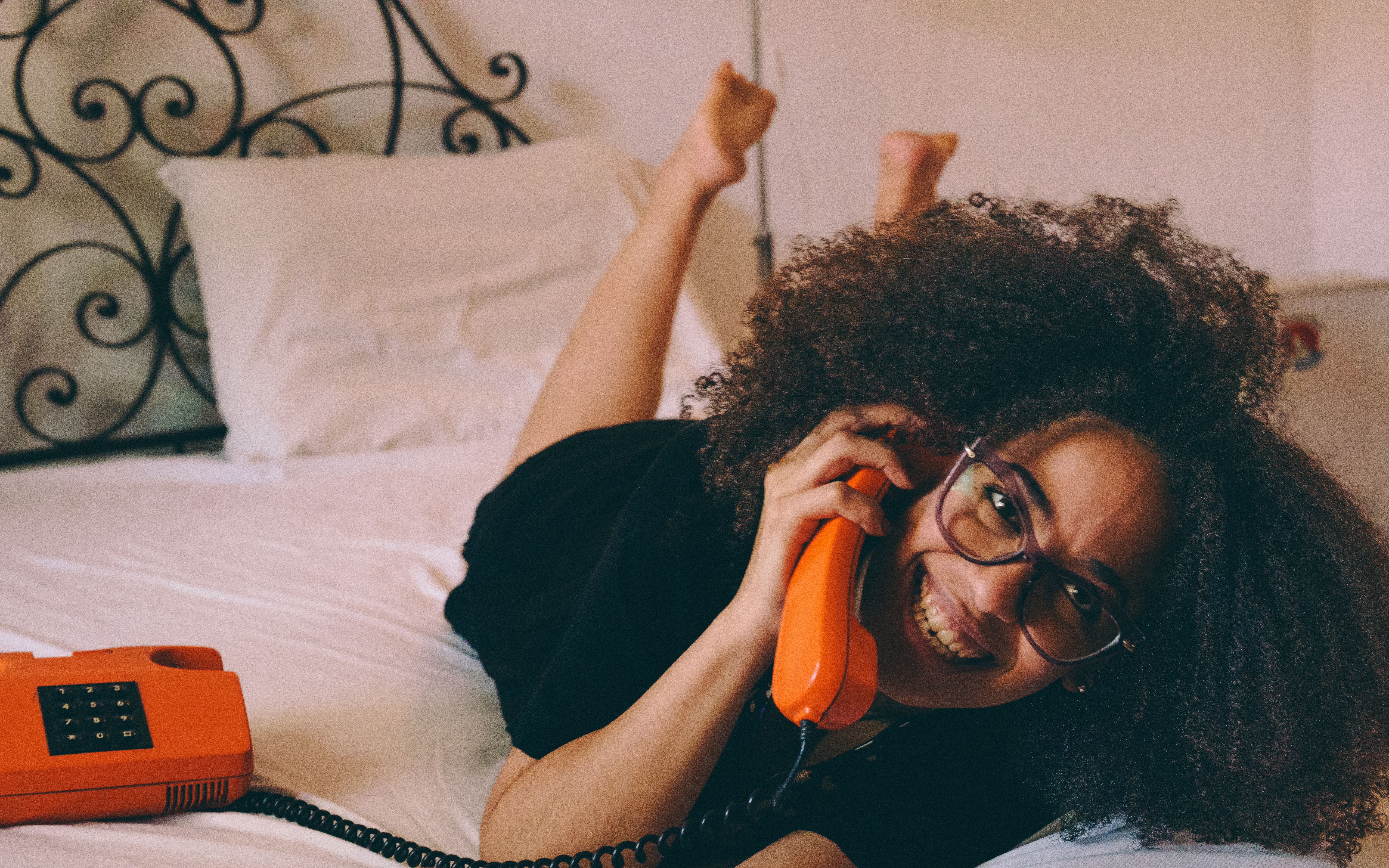 Cheerful Woman Talking on Retro Orange Phone · Free Stock Photo