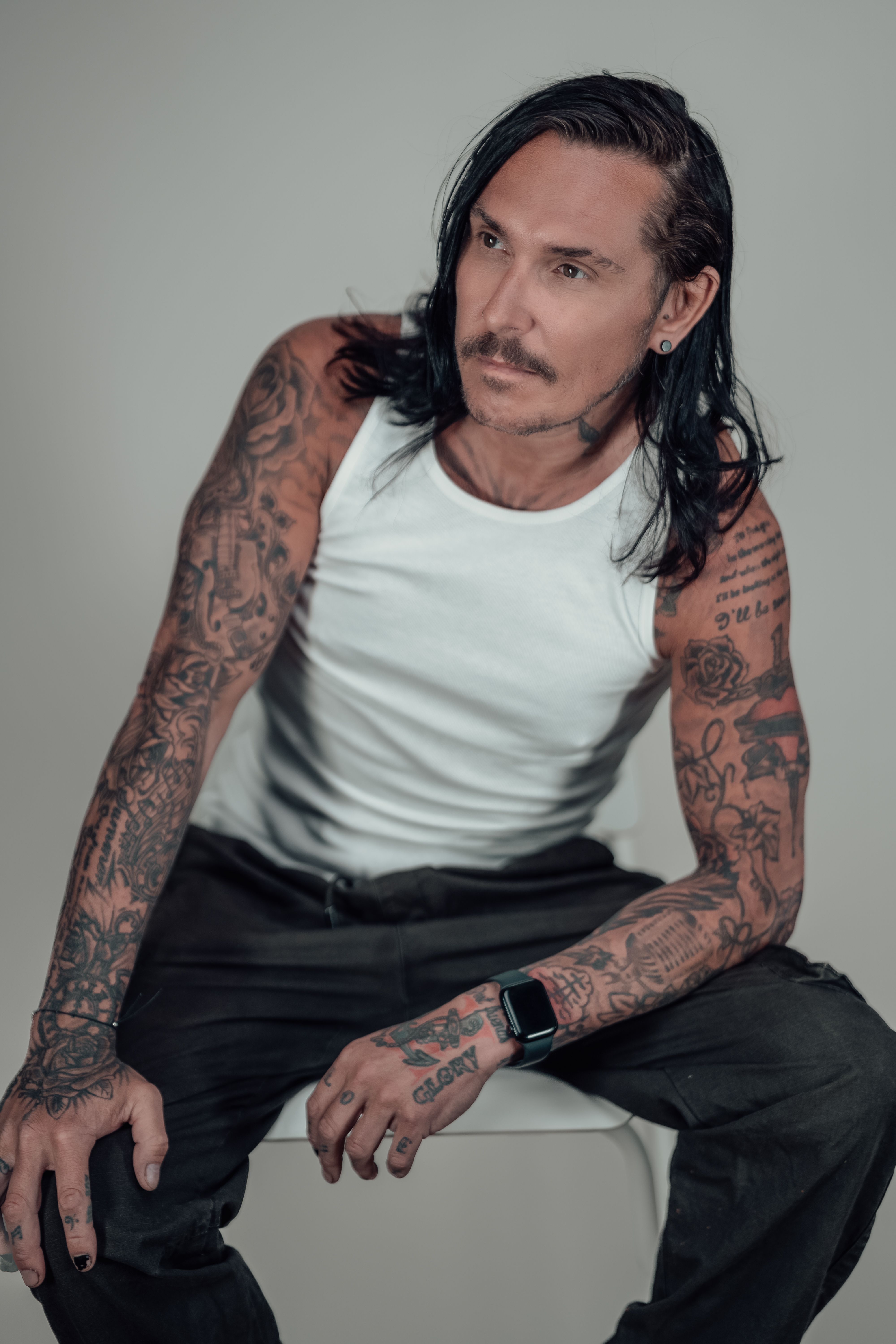 Tattooed Man in White Vest With Black Hair