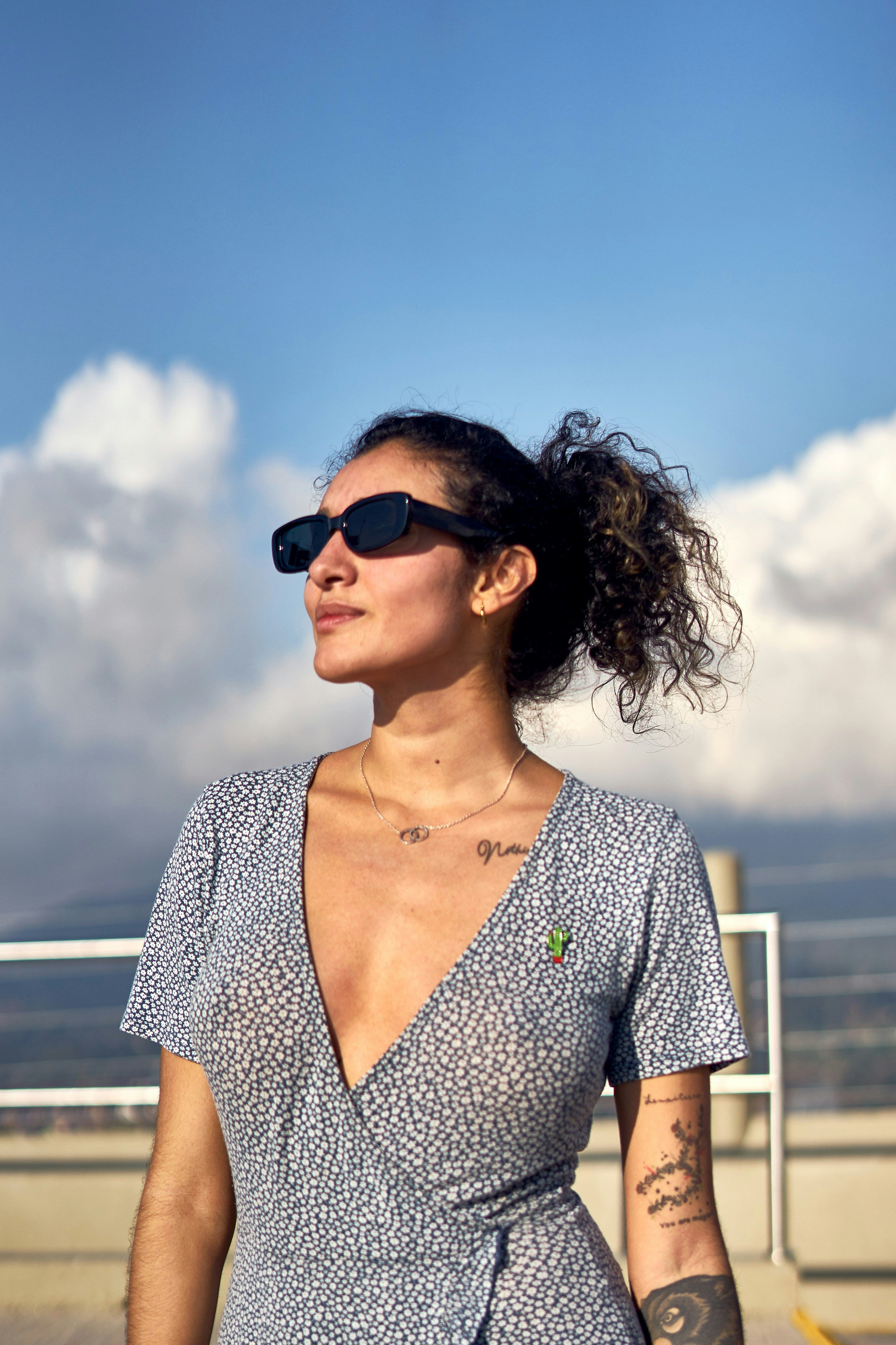 Stylish woman in sunglasses and dress enjoying a sunny day in Antioquia.