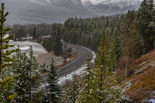 A snowy railway winding through the forested landscape of Jasper, Alberta.